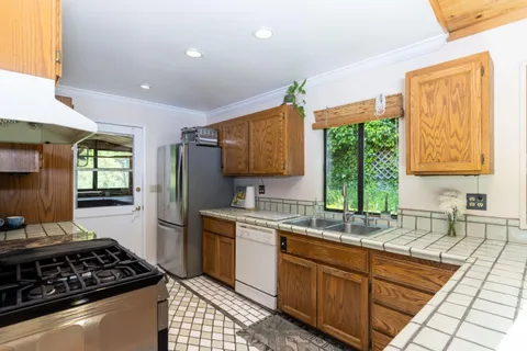 a kitchen with stainless steel appliances a sink stove and cabinets