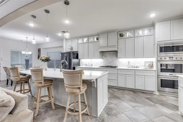 a kitchen with stainless steel appliances granite countertop a sink stove and cabinets