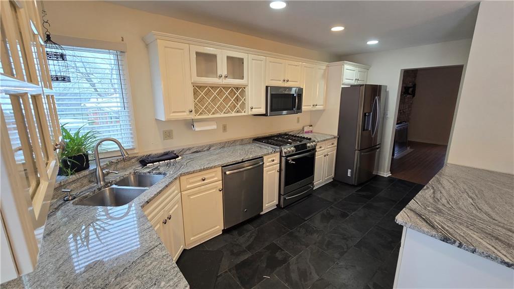 243 Augusta Street Pittsburgh, PA 15211 - Photo 3 of 43 a kitchen with stainless steel appliances granite countertop a refrigerator a sink a stove a washer dryer and a refrigerator