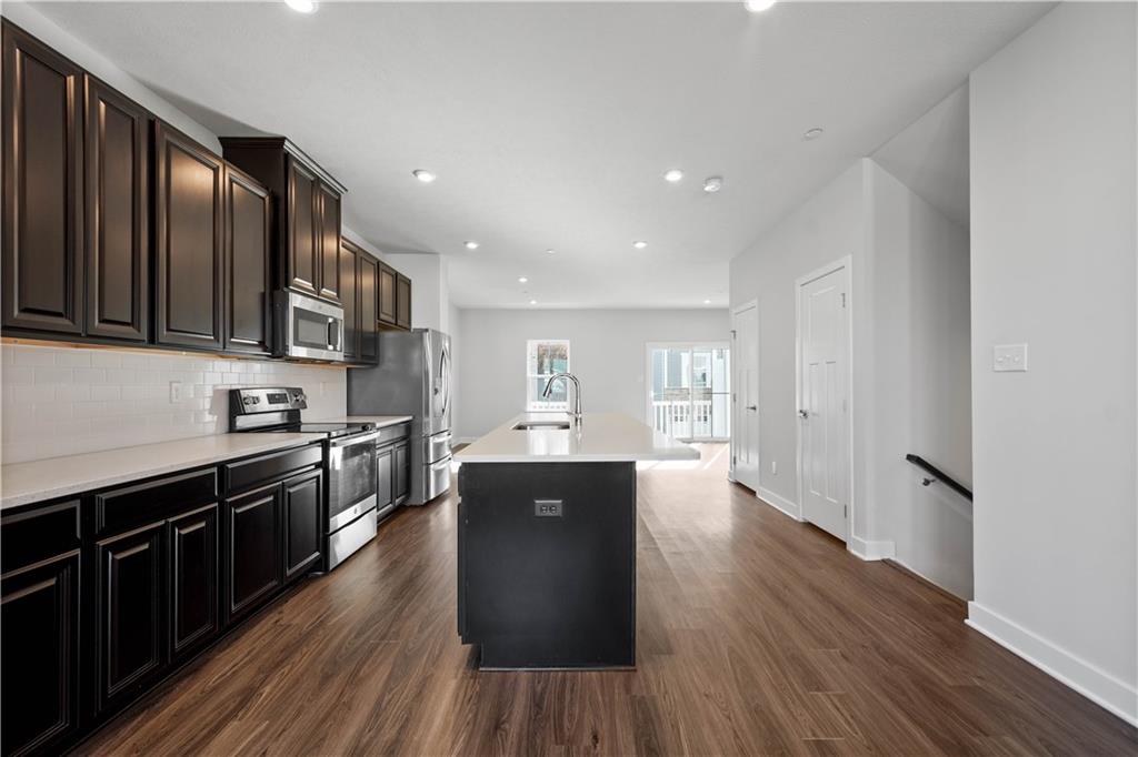 4108 Spruce Road Gibsonia, PA 15044 - Photo 9 of 45 a kitchen with stainless steel appliances granite countertop wooden cabinets a refrigerator a stove a sink and dishwasher with wooden floor