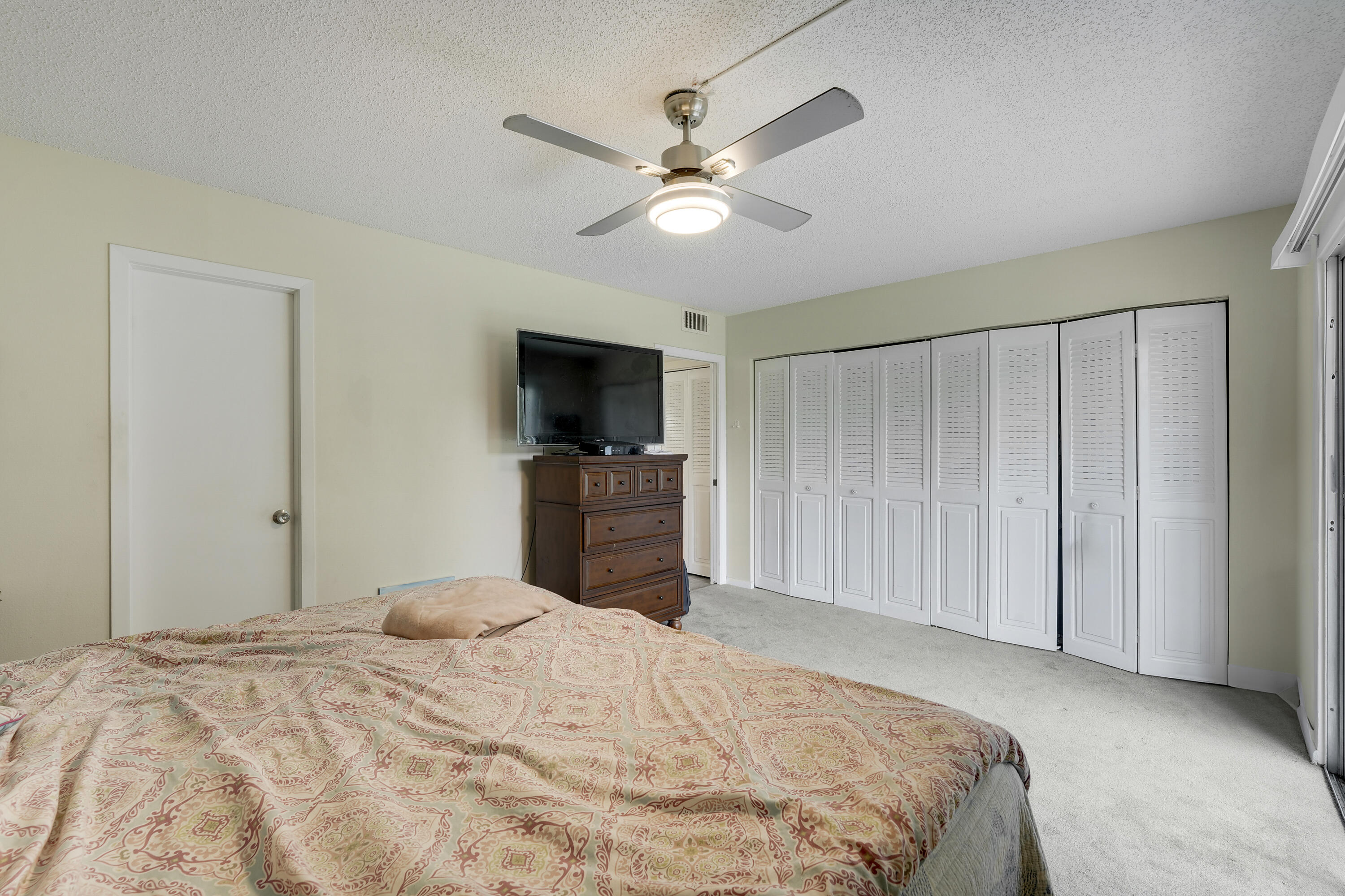 16 Mansfield B Boca Raton, FL 33434 - Photo 11 of 15 a bedroom with a bed and a flat tv screen on dresser