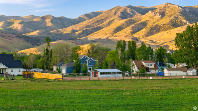 681 Island Road Morgan, UT 84050 - Photo 42 of 49 Expansive green field foregrounding a residential area with varied housing styles