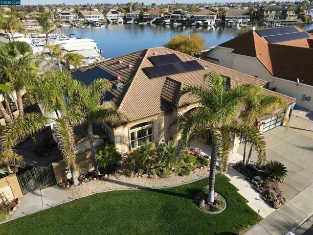 an aerial view of a house with swimming pool and lake view