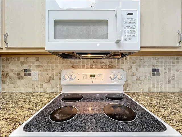 a view of a kitchen with kitchen island granite countertop a sink and a granite counter top