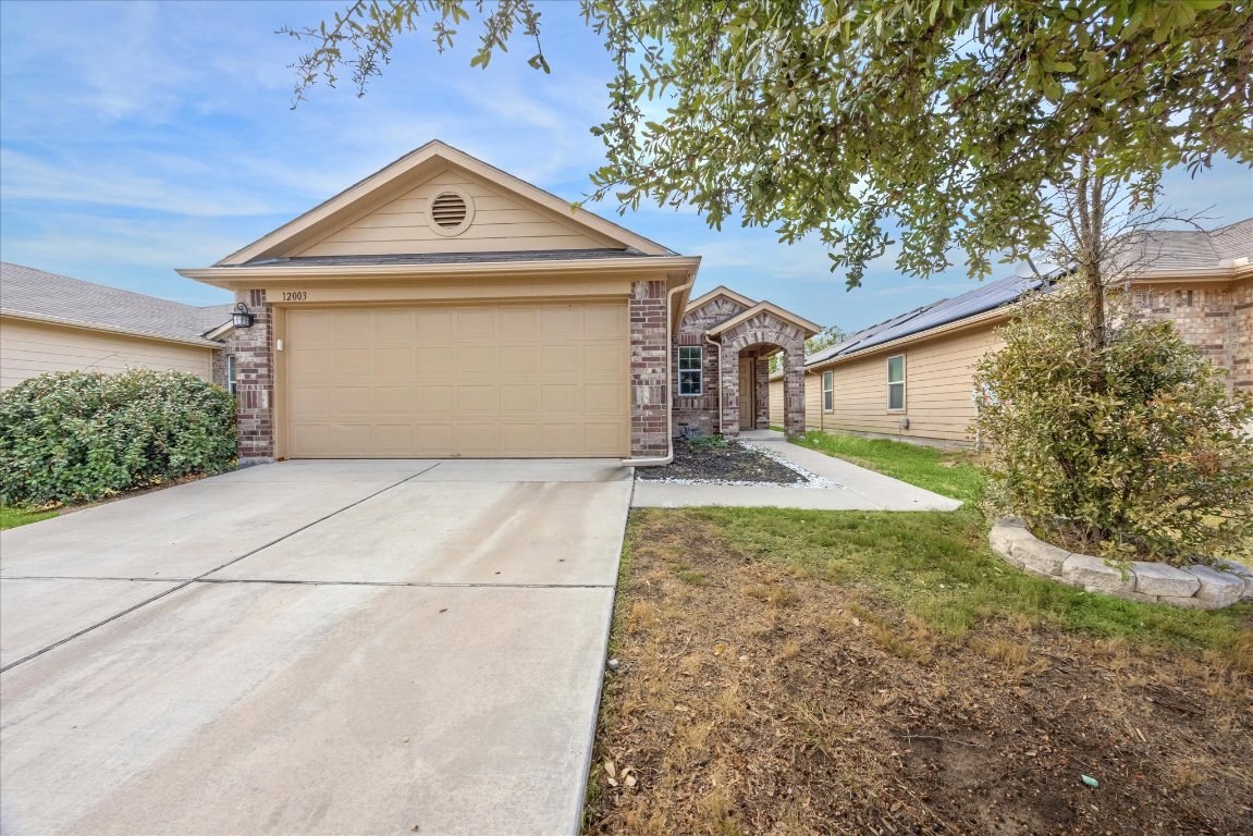 12003 Waterford Run Way Manor, TX 78653 - Photo 1 of 7 a front view of a house with a yard and garage