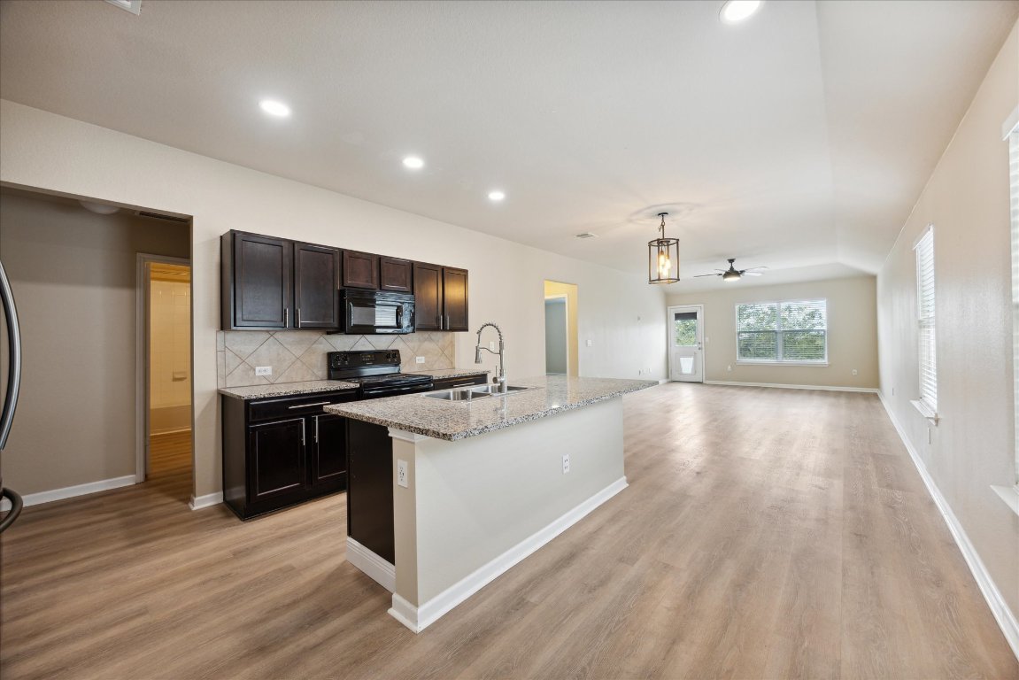 12003 Waterford Run Way Manor, TX 78653 - Photo 2 of 7 a large kitchen with stainless steel appliances granite countertop a stove and a refrigerator