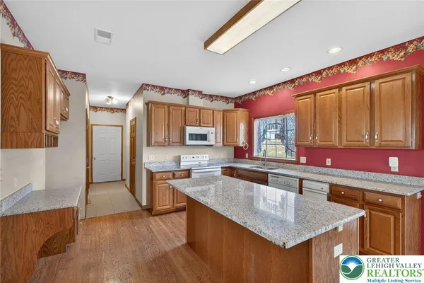 a kitchen with stainless steel appliances granite countertop a sink and a refrigerator