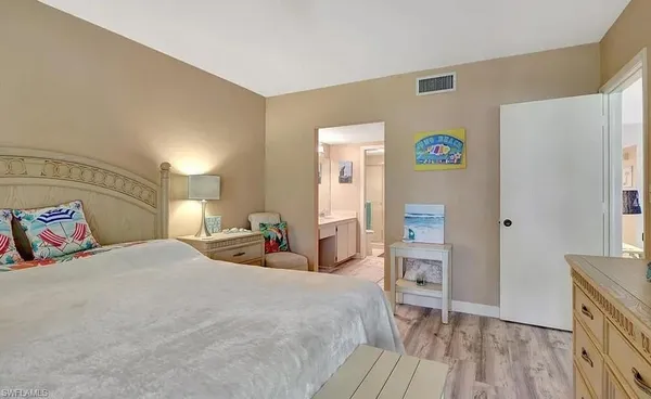 a bedroom with a bed and a flat tv screen on dresser