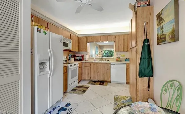a kitchen with a refrigerator a stove top oven a sink and a window