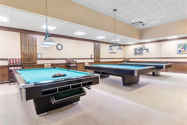 a room with pool table and windows