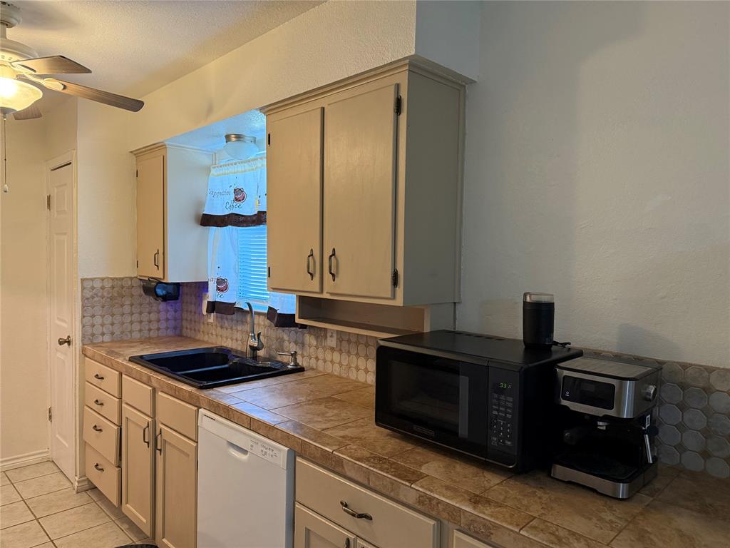 58 Roberts Road Mineral Wells, TX 76067 - Photo 11 of 28 a kitchen with a sink and cabinets