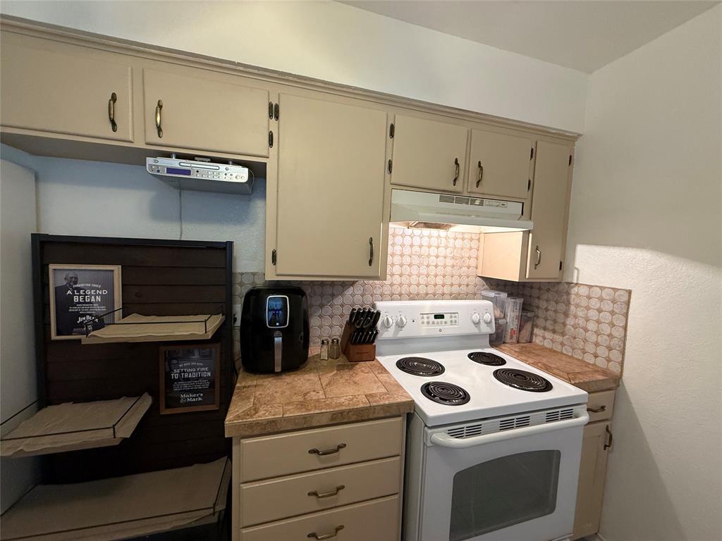 58 Roberts Road Mineral Wells, TX 76067 - Photo 12 of 28 a kitchen with a stove and a refrigerator