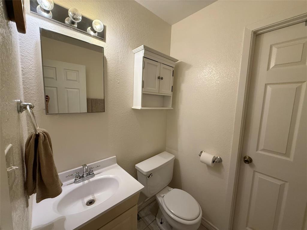 58 Roberts Road Mineral Wells, TX 76067 - Photo 24 of 28 a bathroom with a toilet sink and mirror