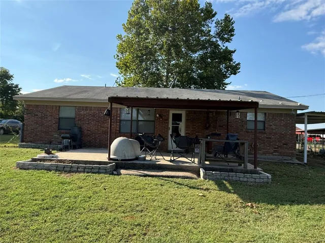 a view of a house with backyard and sitting area