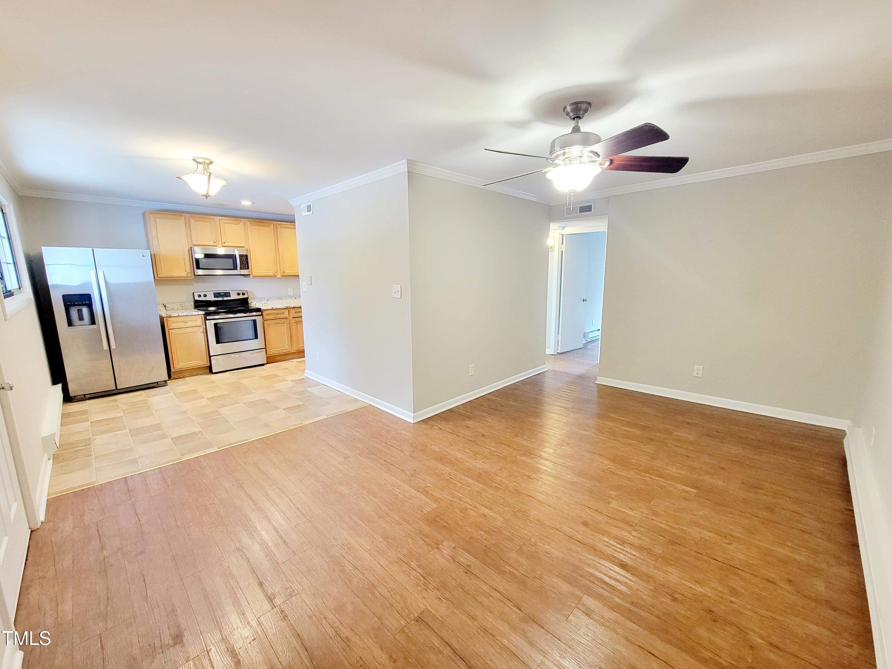 1422 Scales Street, Unit C Raleigh, NC 27608 - Photo 12 of 37 a view of a room with a ceiling fan window and wooden floor