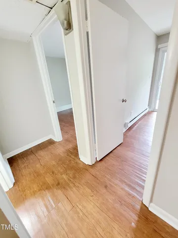 an empty room with wooden floor and stairs