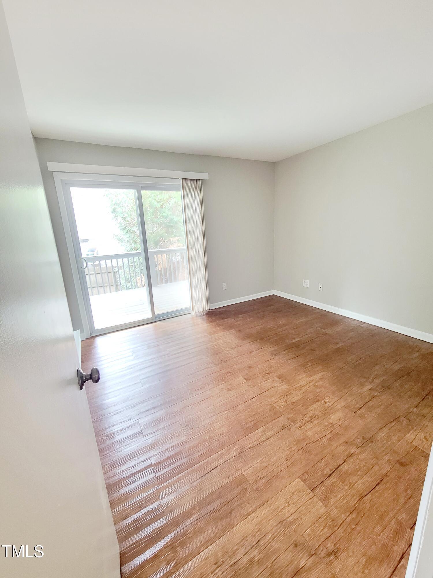 1422 Scales Street, Unit C Raleigh, NC 27608 - Photo 16 of 37 an empty room with wooden floor and windows