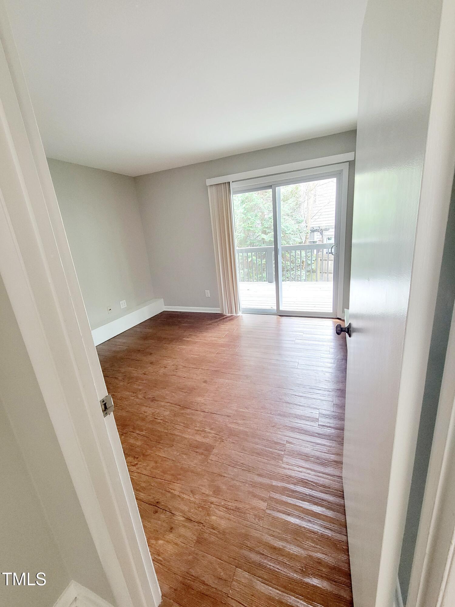 1422 Scales Street, Unit C Raleigh, NC 27608 - Photo 22 of 37 a view of an empty room with wooden floor and a window