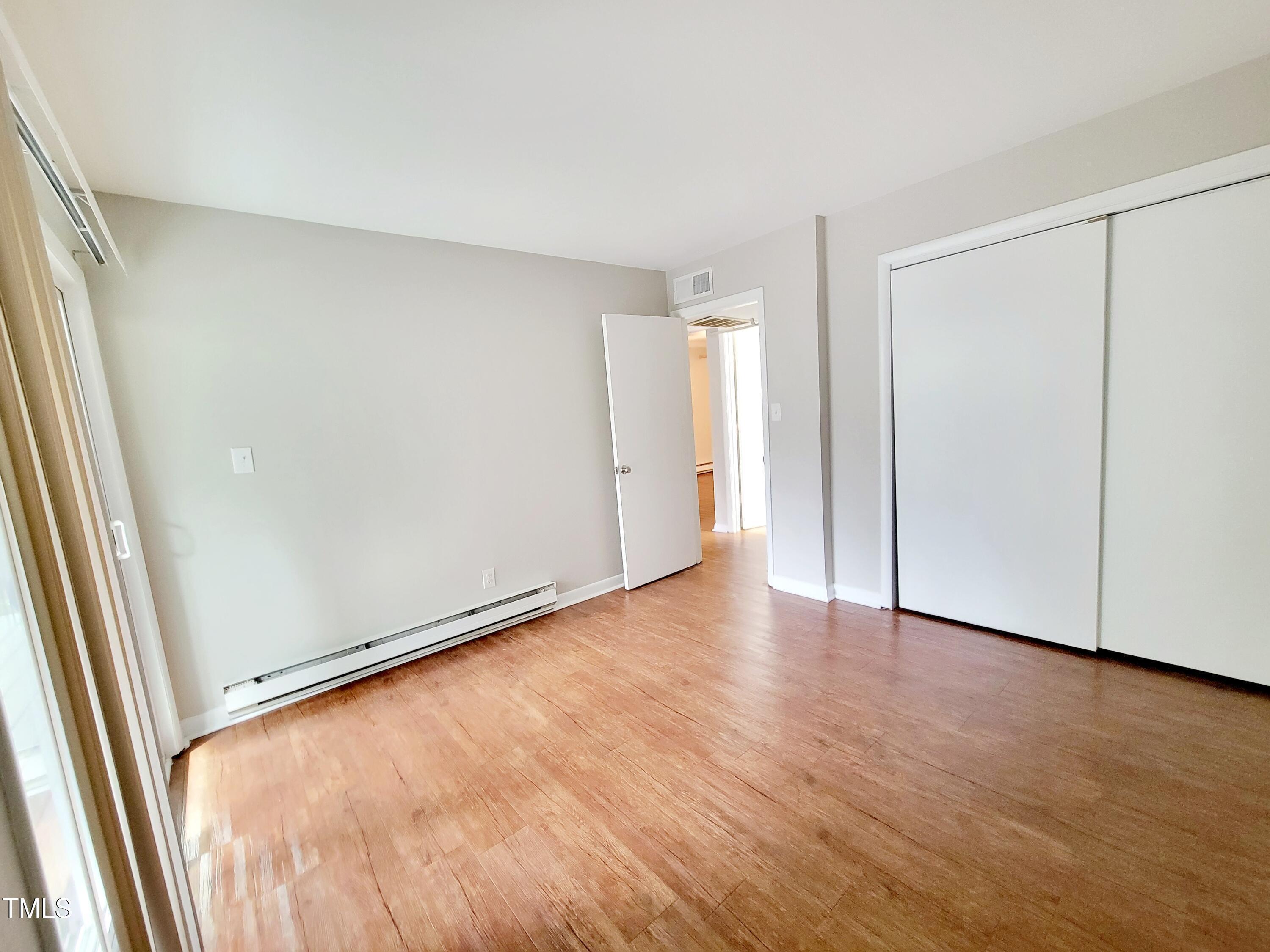 1422 Scales Street, Unit C Raleigh, NC 27608 - Photo 25 of 37 an empty room with wooden floor and windows