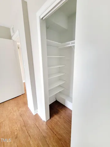 a view of walk in closet with empty racks