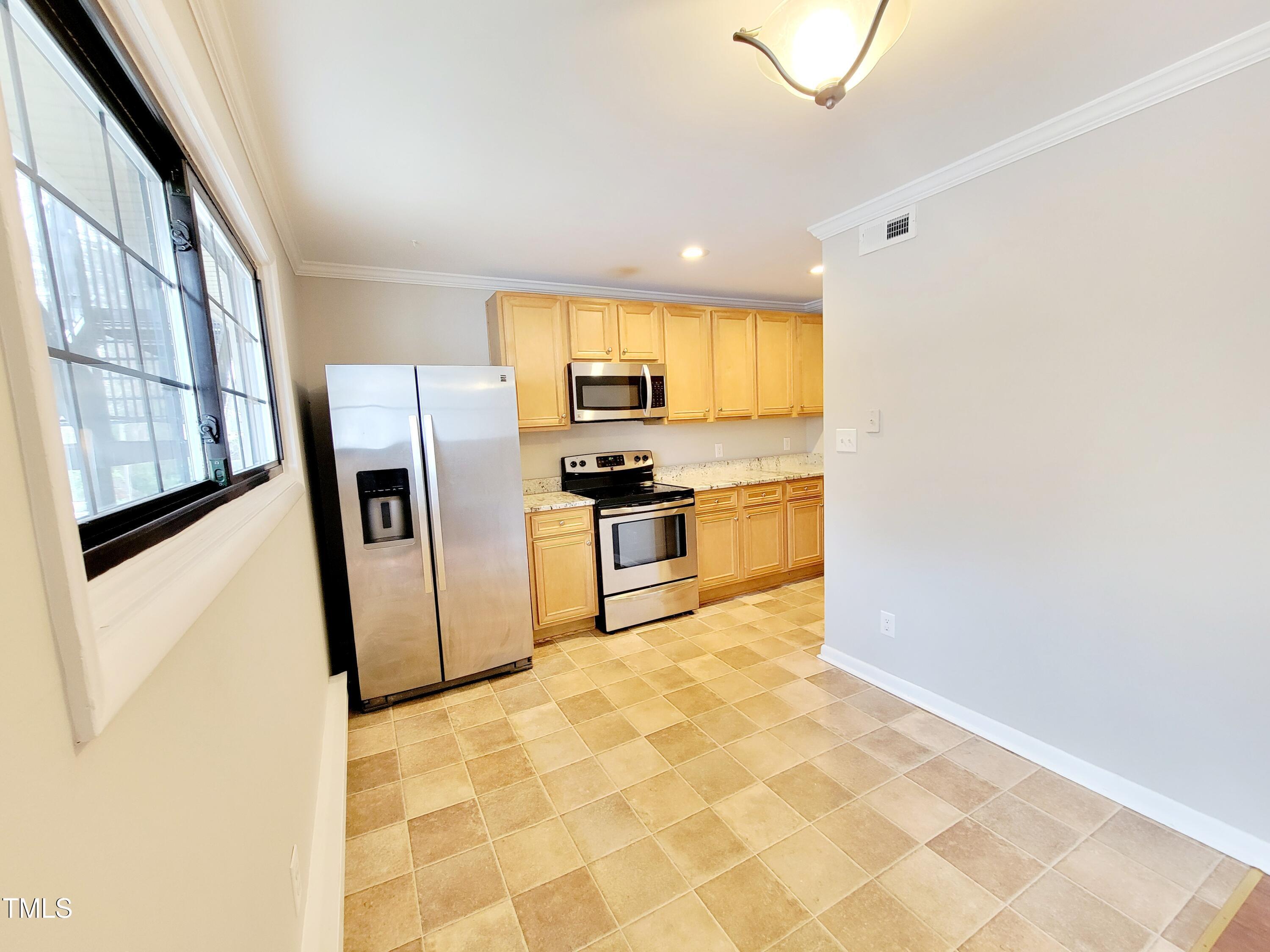 1422 Scales Street, Unit C Raleigh, NC 27608 - Photo 3 of 37 a kitchen with stainless steel appliances granite countertop a refrigerator and a sink