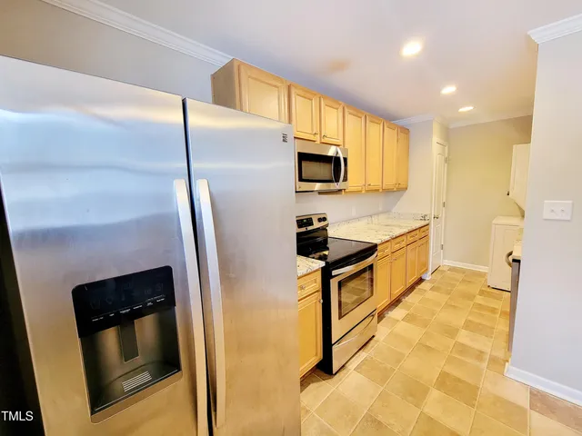 a kitchen with stainless steel appliances a refrigerator a stove a microwave and cabinets