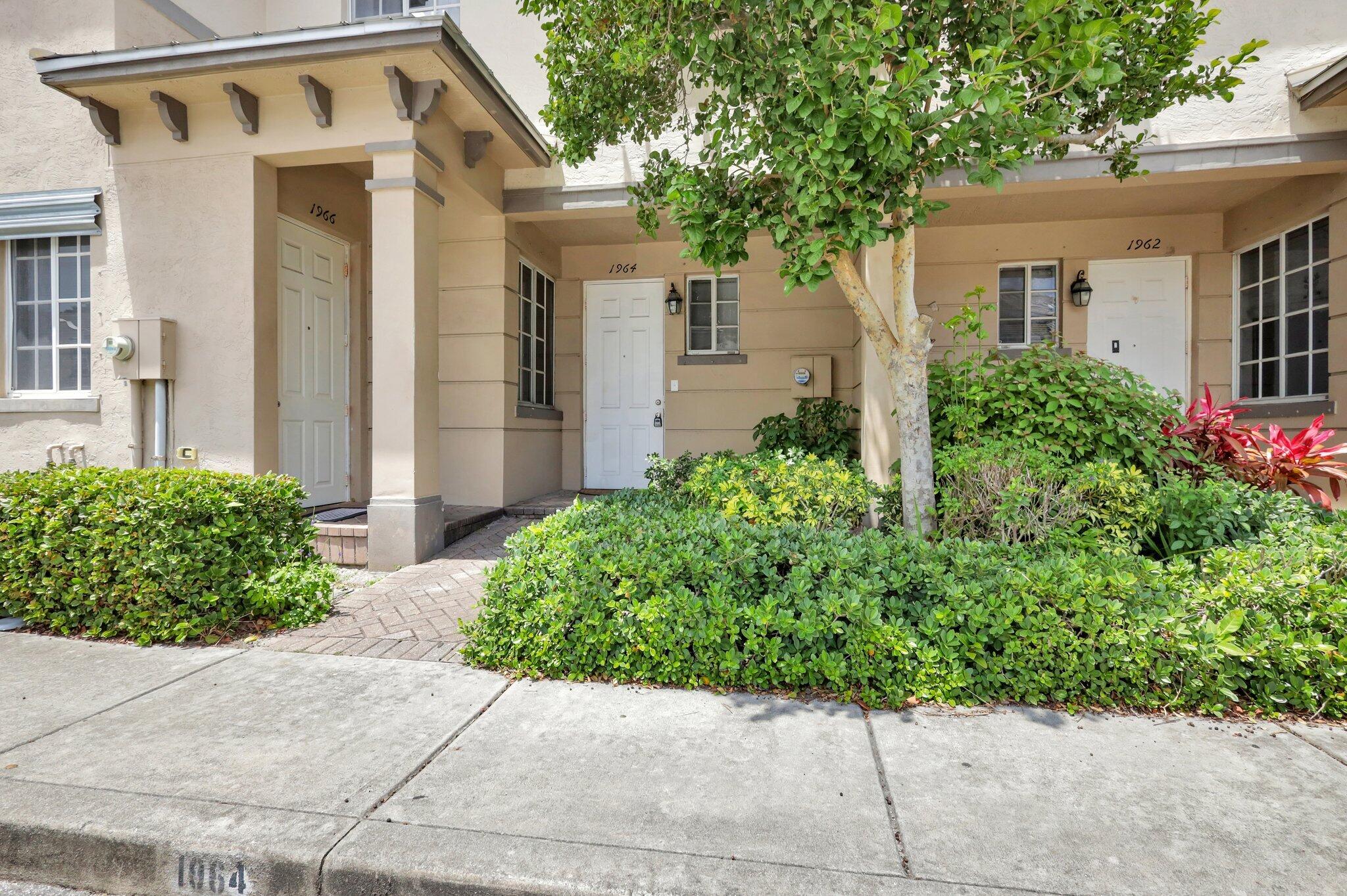 1964 Freeport Drive, Unit 1964 Riviera Beach, FL 33404 - Photo 1 of 20 a front view of a house with garden