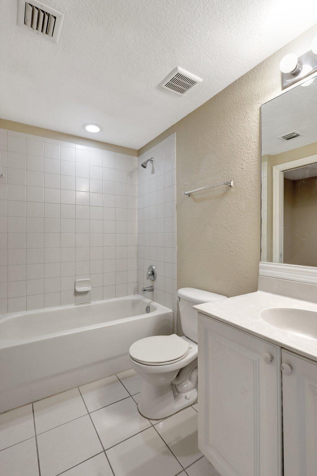 1964 Freeport Drive, Unit 1964 Riviera Beach, FL 33404 - Photo 13 of 20 a bathroom with a toilet a sink and bathtub