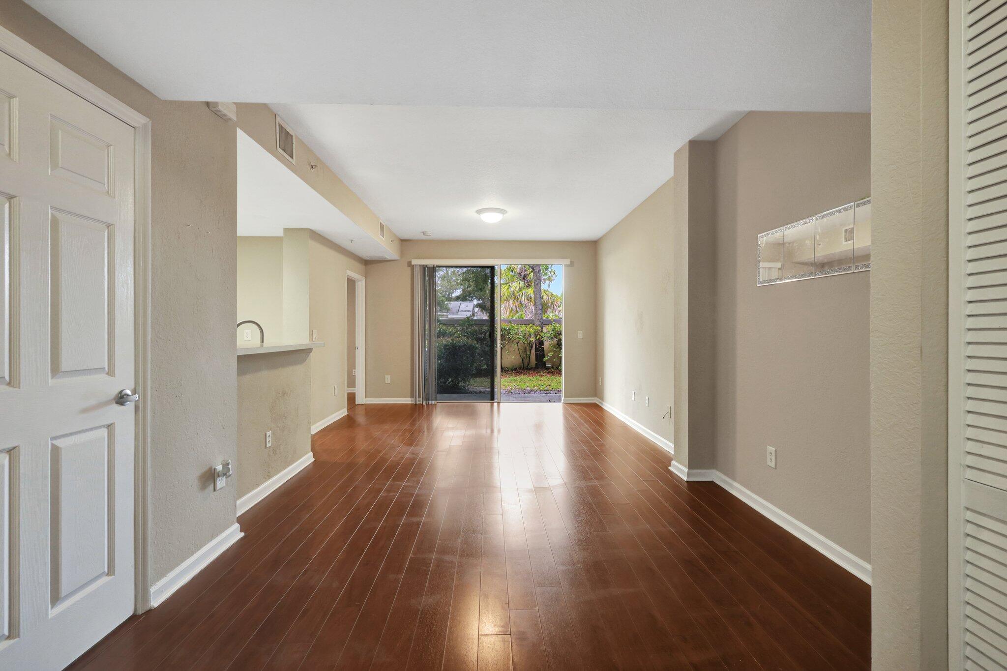 1964 Freeport Drive, Unit 1964 Riviera Beach, FL 33404 - Photo 2 of 20 a view of a big room with wooden floor and windows