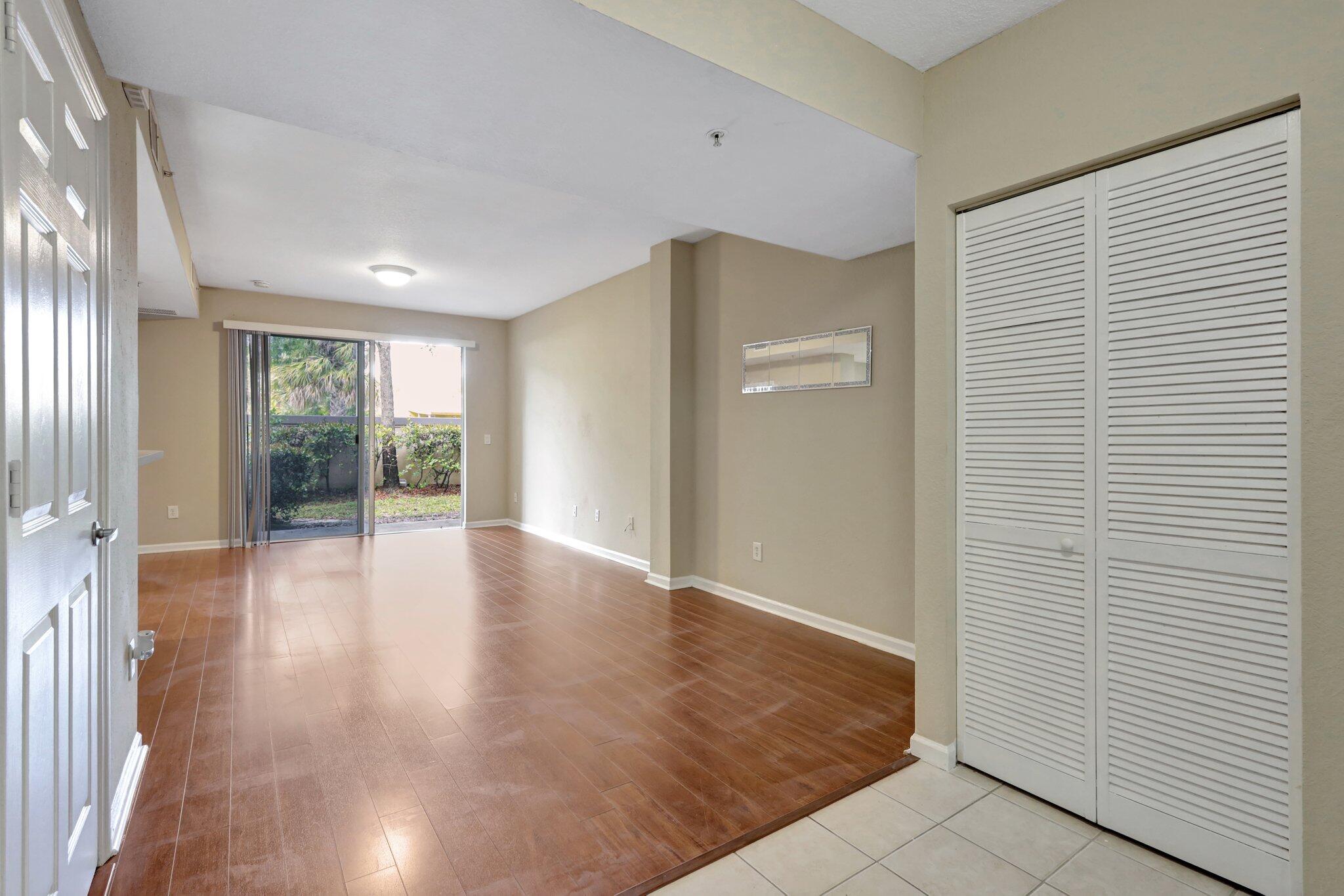 1964 Freeport Drive, Unit 1964 Riviera Beach, FL 33404 - Photo 3 of 20 a view of an empty room with wooden floor and a window