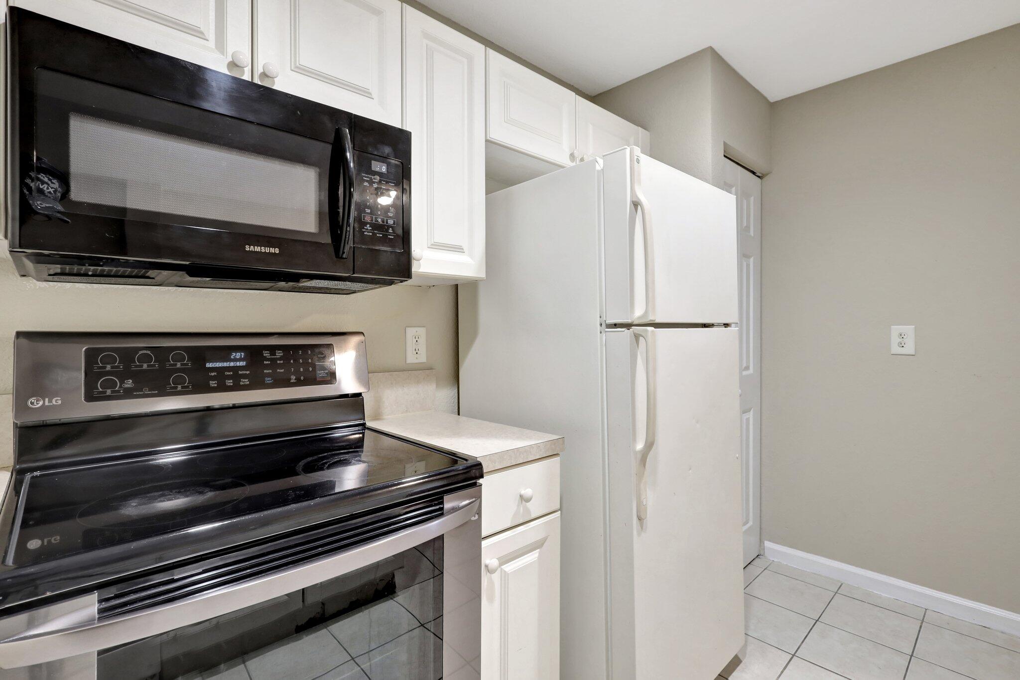 1964 Freeport Drive, Unit 1964 Riviera Beach, FL 33404 - Photo 8 of 20 a view of kitchen stove microwave and refrigerator