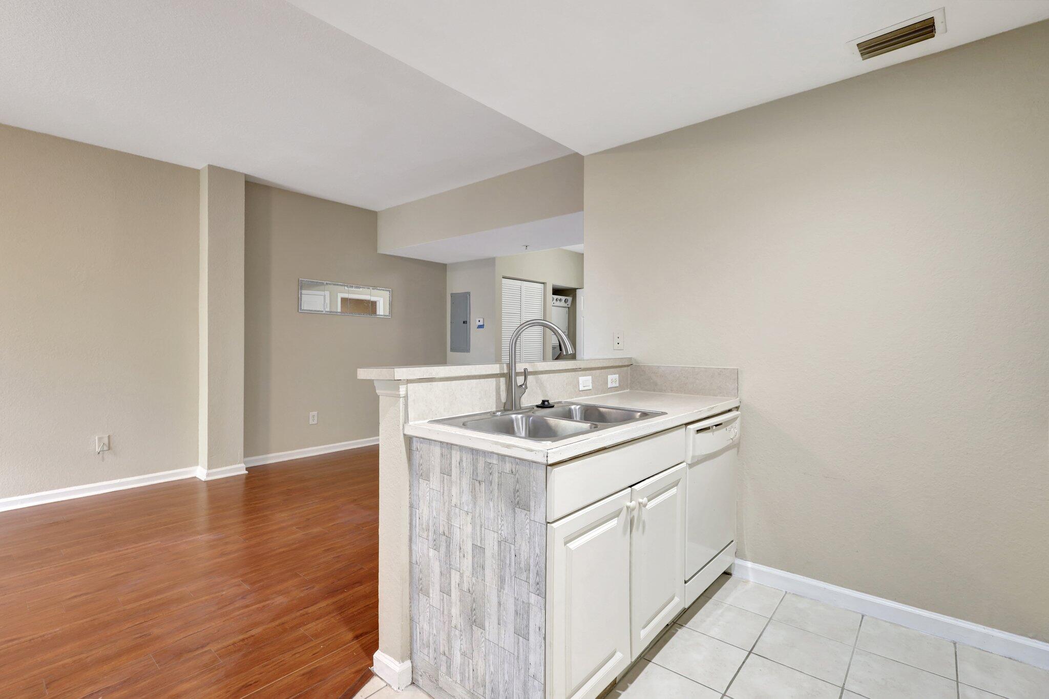 1964 Freeport Drive, Unit 1964 Riviera Beach, FL 33404 - Photo 9 of 20 a kitchen with a sink cabinets and a wooden floor