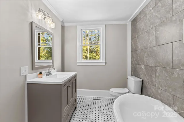 a bathroom with a sink a toilet and window