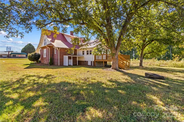 a house with huge green field and large trees
