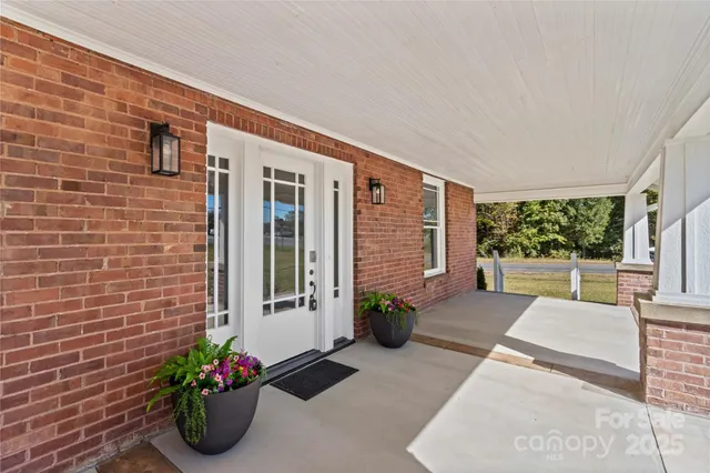 a view of a porch with chairs and potted plants