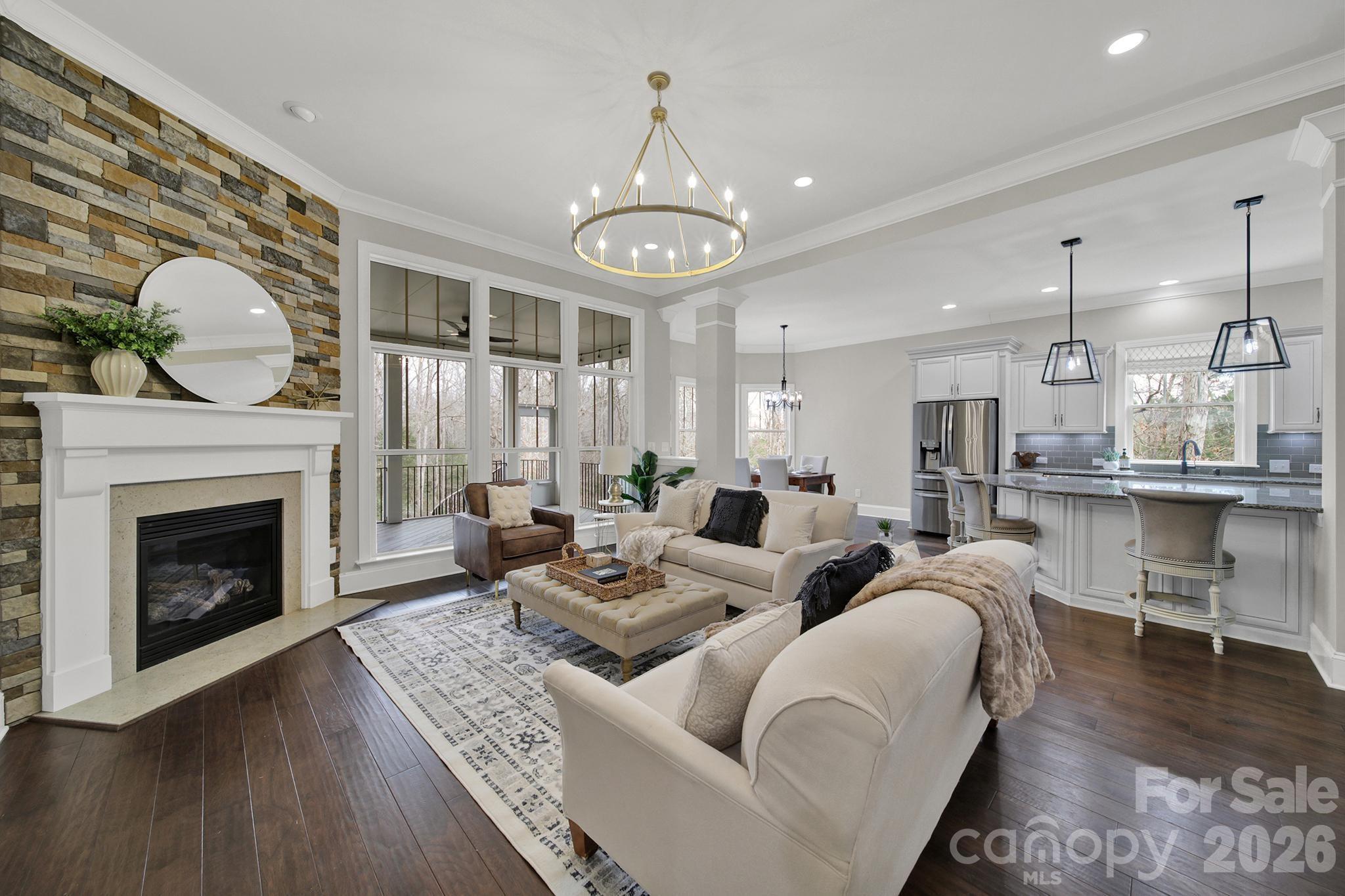 2112 Tatton Hall Road Fort Mill, SC 29715 - Photo 11 of 46 a living room with couches a fireplace and kitchen view with wooden floor