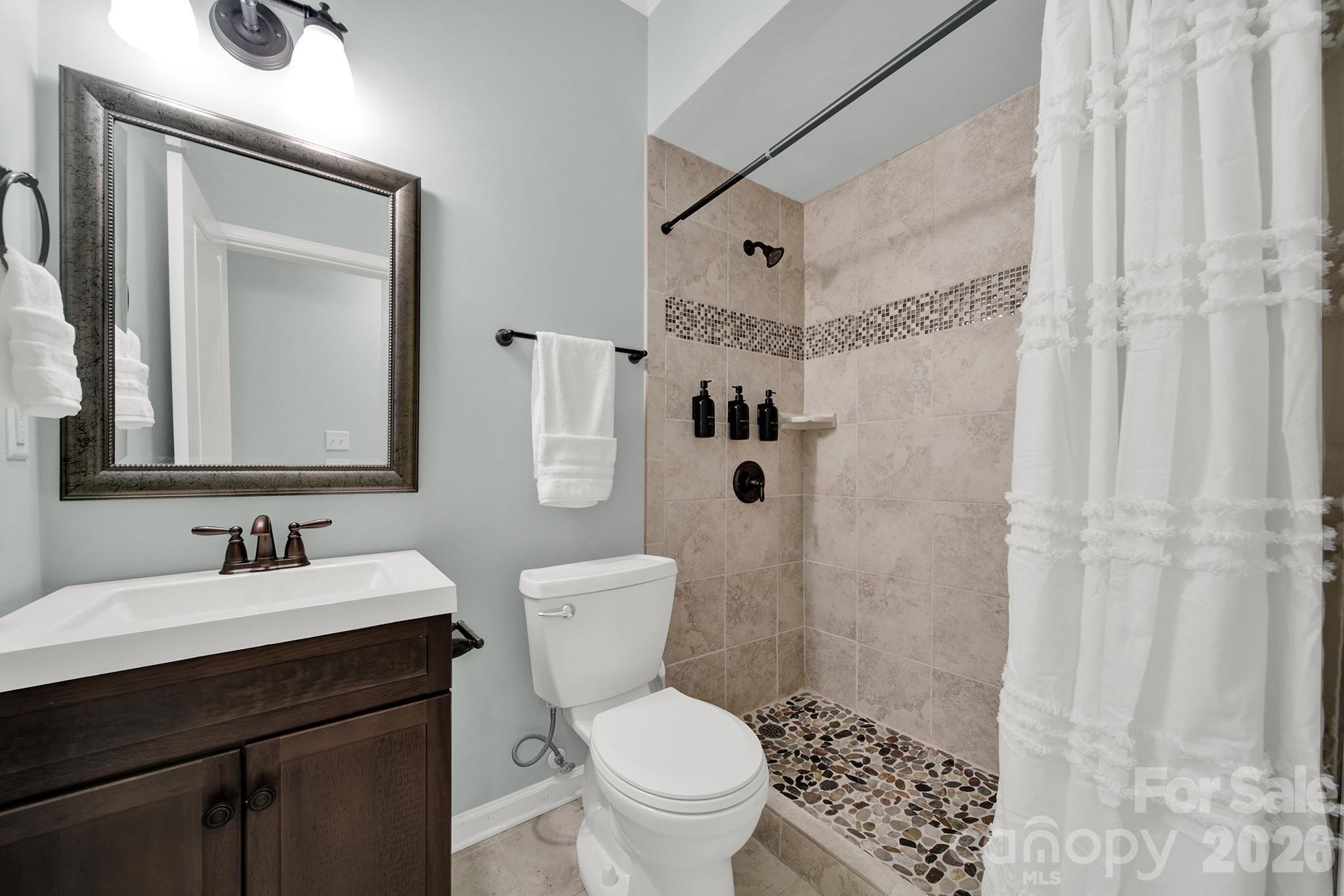 2112 Tatton Hall Road Fort Mill, SC 29715 - Photo 31 of 46 a bathroom with a sink a toilet a mirror and shower