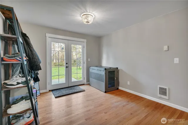 a view of an empty room with a window and wooden floor