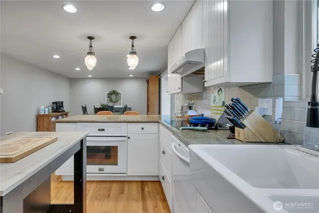 a kitchen with stainless steel appliances granite countertop a sink and a white cabinets