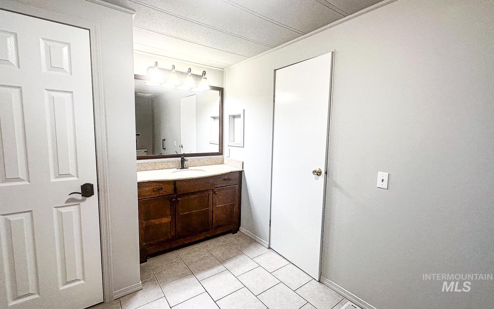 1200 Artesian Road Eagle, ID 83616 - Photo 12 of 18 Half bath featuring vanity and light tile patterned flooring