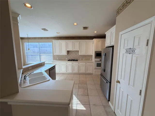 a kitchen with granite countertop a refrigerator and a sink