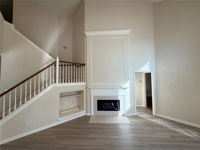 a view of a livingroom with wooden floor and a fireplace