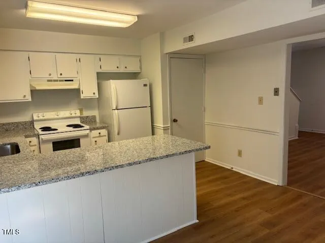 a kitchen with stainless steel appliances granite countertop a refrigerator a sink and a stove