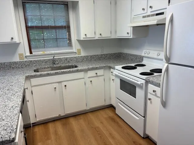 a kitchen with granite countertop white cabinets and white appliances