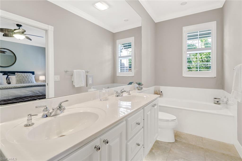 8028 Josefa Way Naples, FL 34114 - Photo 15 of 27 a bathroom with a granite countertop sink double vanity and bathtub
