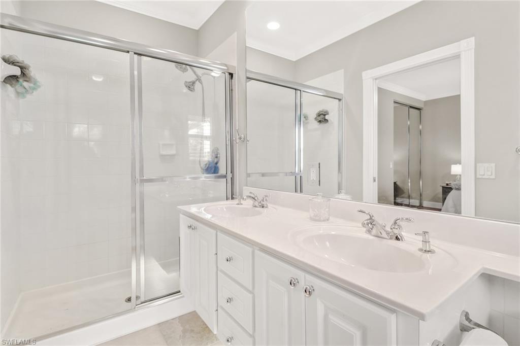8028 Josefa Way Naples, FL 34114 - Photo 16 of 27 a bathroom with a shower sink vanity and mirror