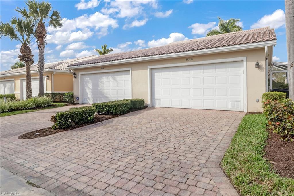 8028 Josefa Way Naples, FL 34114 - Photo 24 of 27 a front view of a house with a yard and garage
