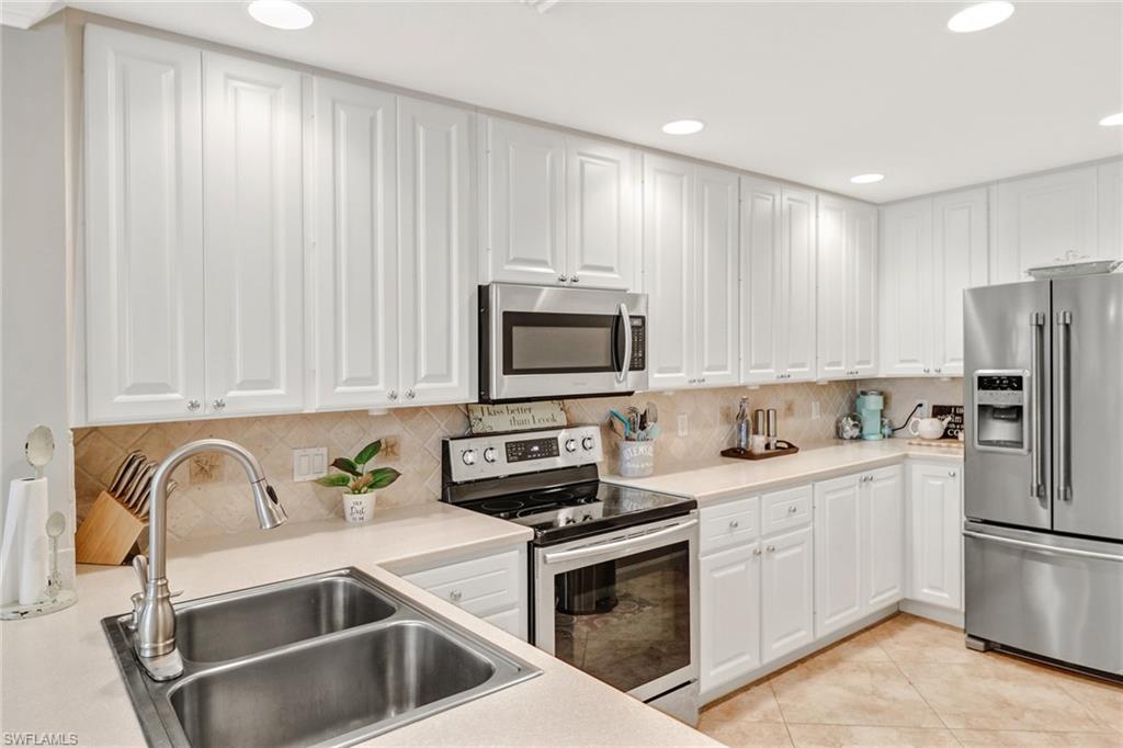 8028 Josefa Way Naples, FL 34114 - Photo 9 of 27 a kitchen with a sink cabinets and stainless steel appliances
