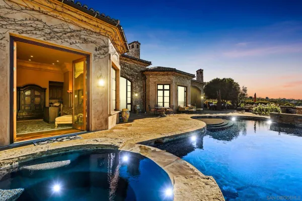 a view of a house with swimming pool next to a yard