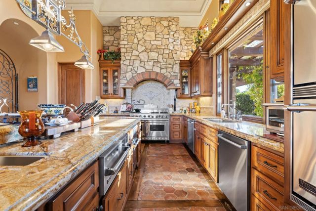 a large kitchen with stainless steel appliances granite countertop a lot of counter space and a sink